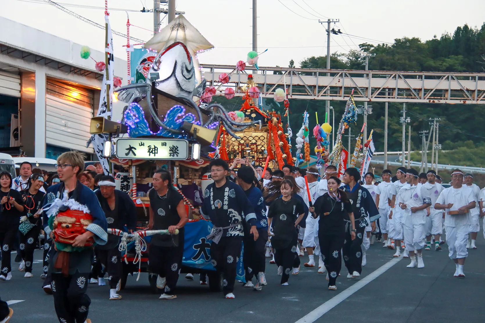 Yamada Daikagura float and marchers with a lion head at dusk during Yamada Matsuri