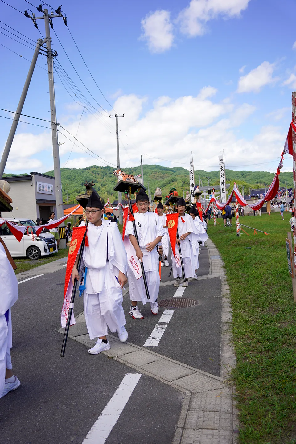 White-robed procession of Osugi Shrine carrying zodiac animal figures at Yamada Matsuri