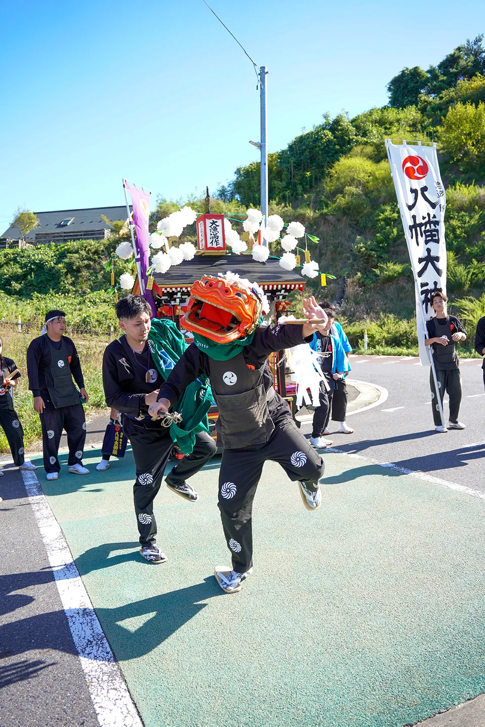 Lion dancer leaping in front of Hachiman Daikagura banners at Yamada Matsuri