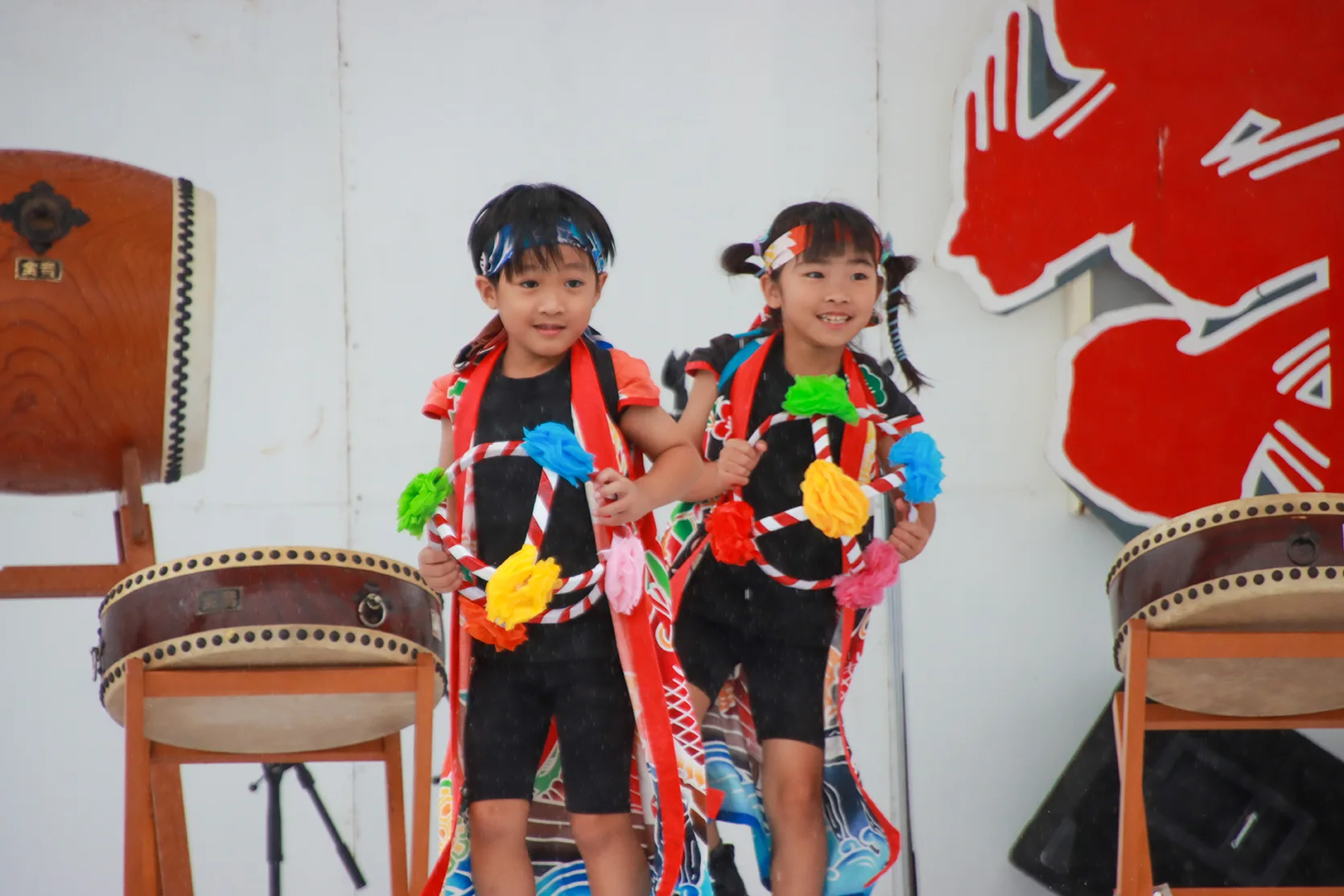 Small children dancing with flower hoops on stage at Yamada Matsuri
