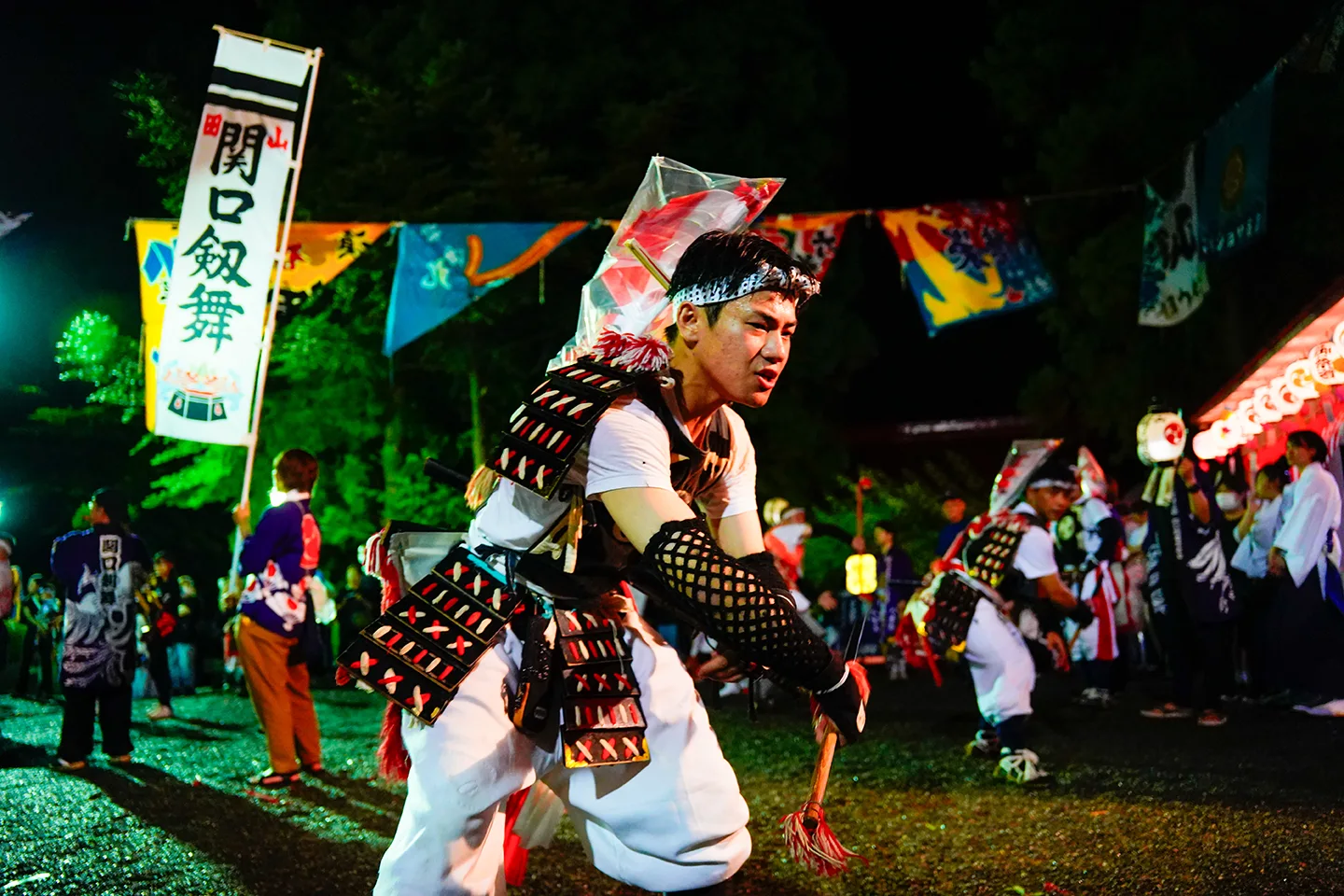 Sekiguchi Kenbai sword dancer performing at night under banners at Yamada Matsuri